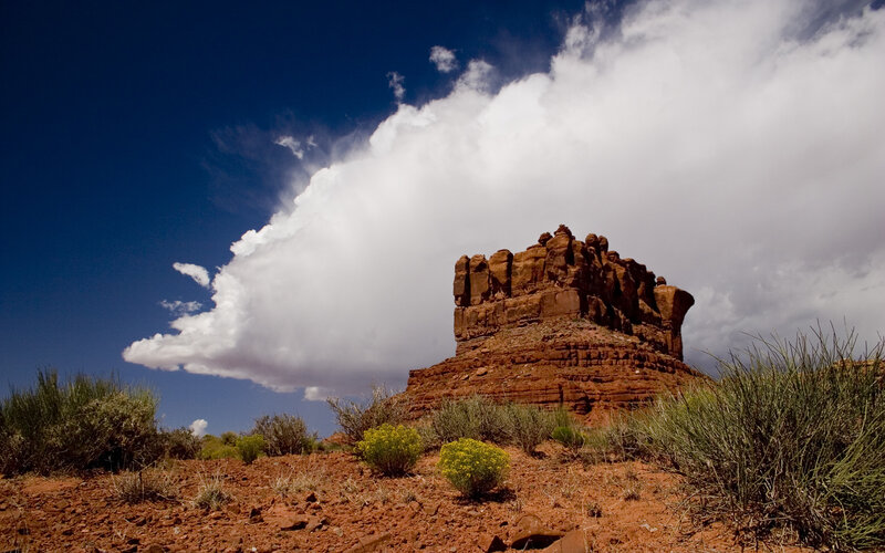 Red rock formation under storm cloud