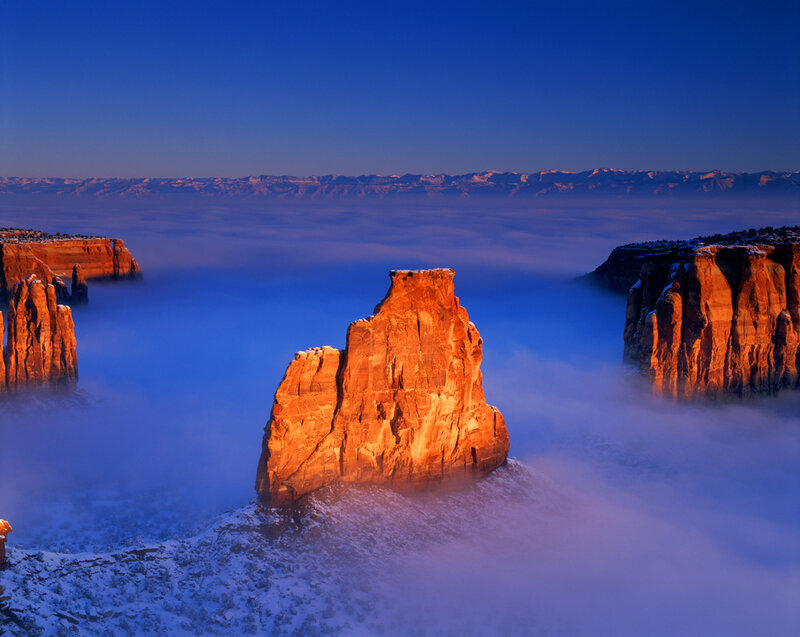 Red rock formations above sea of clouds
