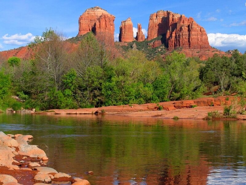 Red rock formations by a river