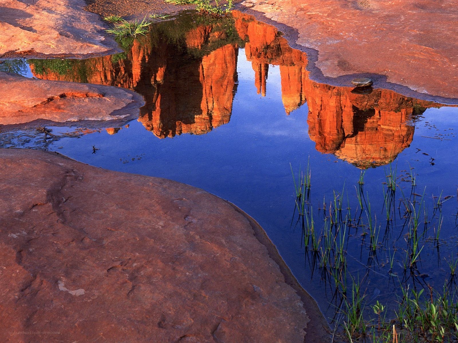 Red rock formations reflected in water