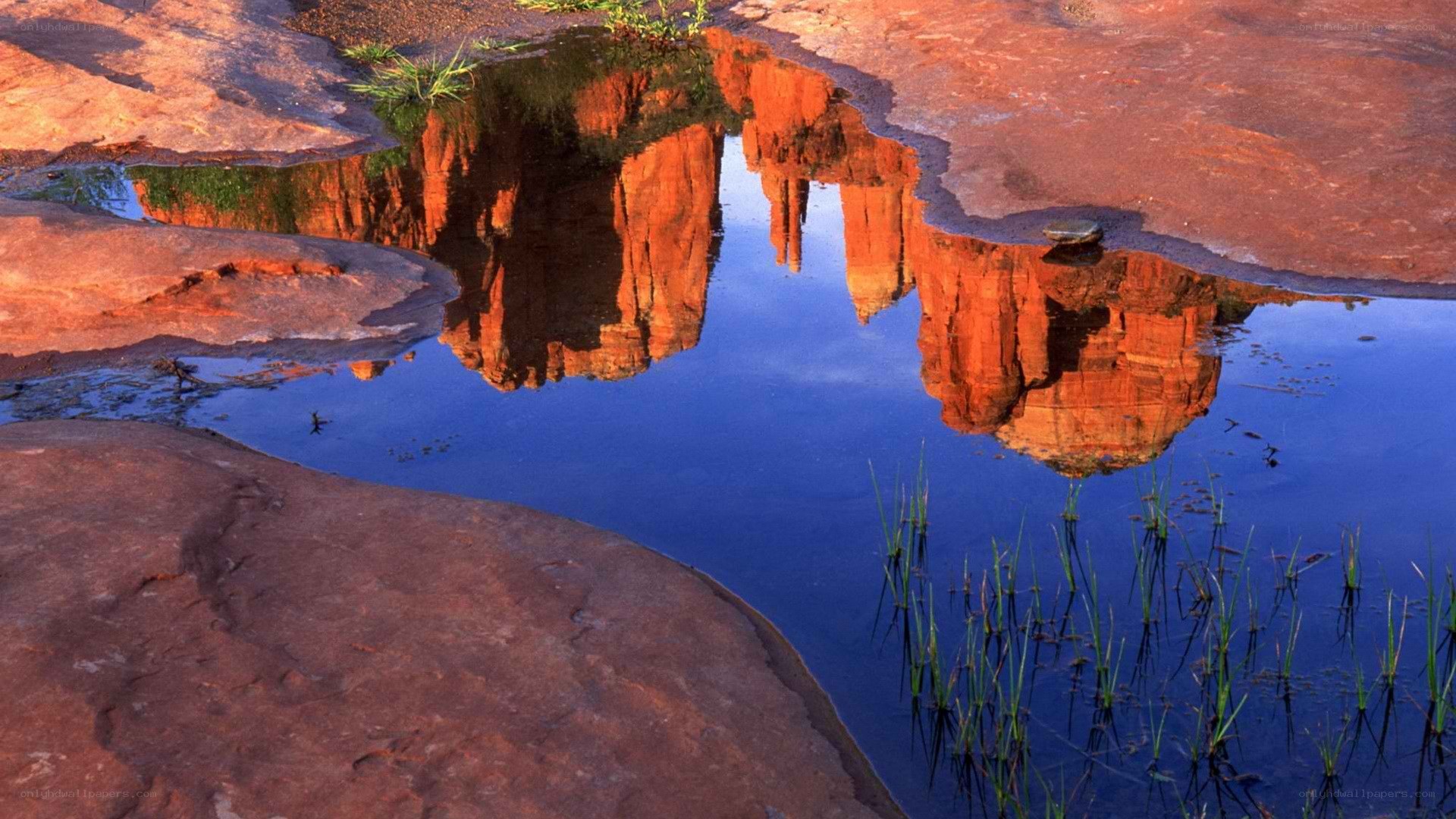 Red rock formations reflected in water