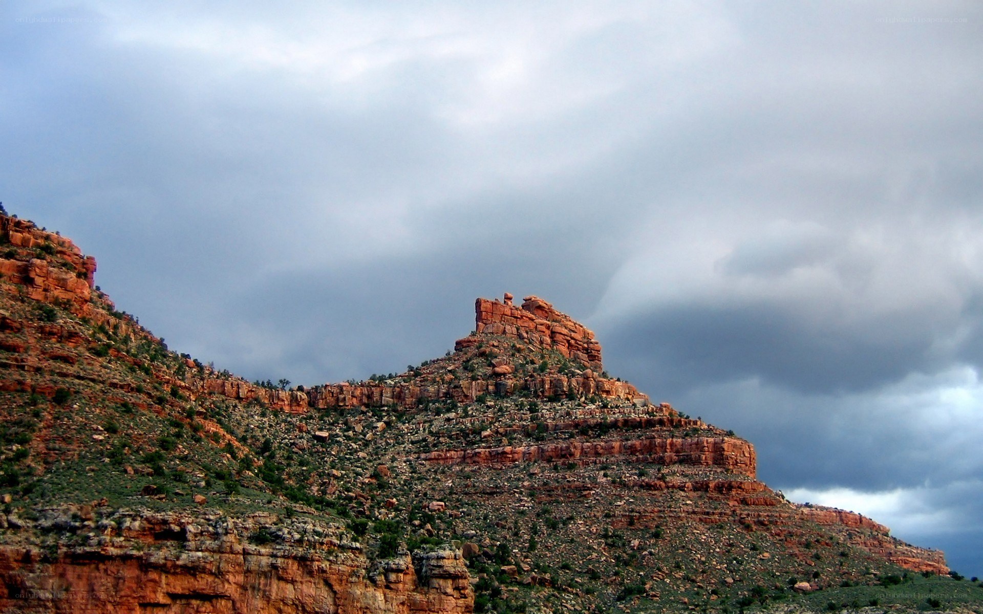 Red rock formations under stormy sky