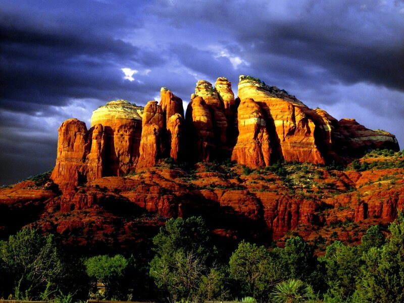 Red rock formations under stormy sky