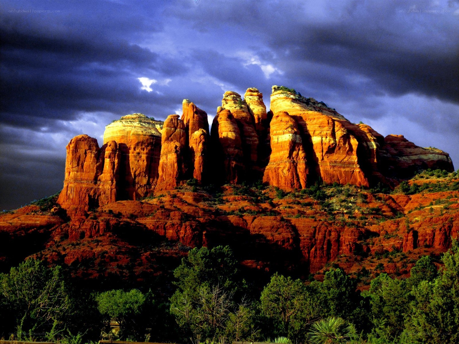 Red rock formations under stormy sky