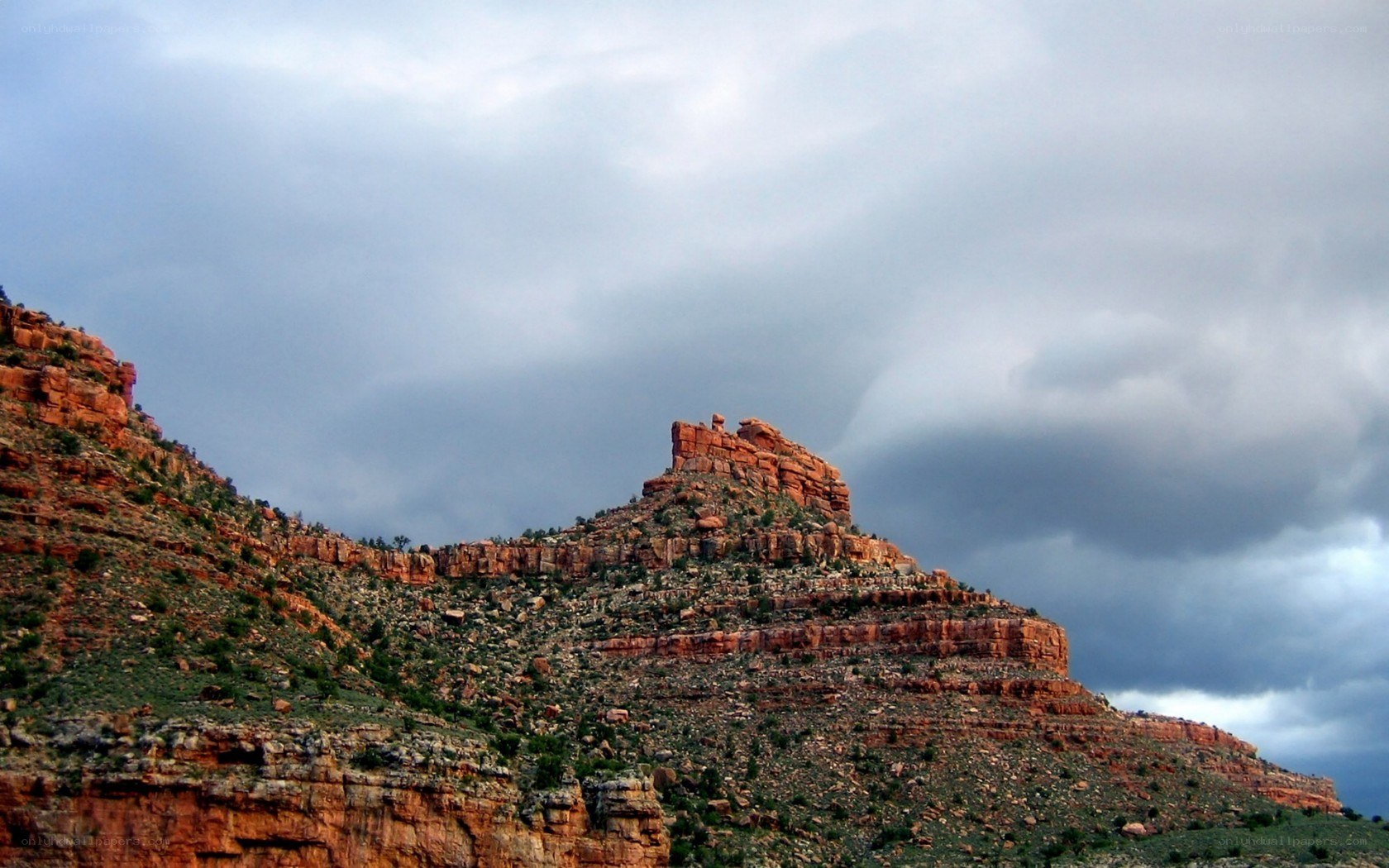 Red rock formations under stormy sky