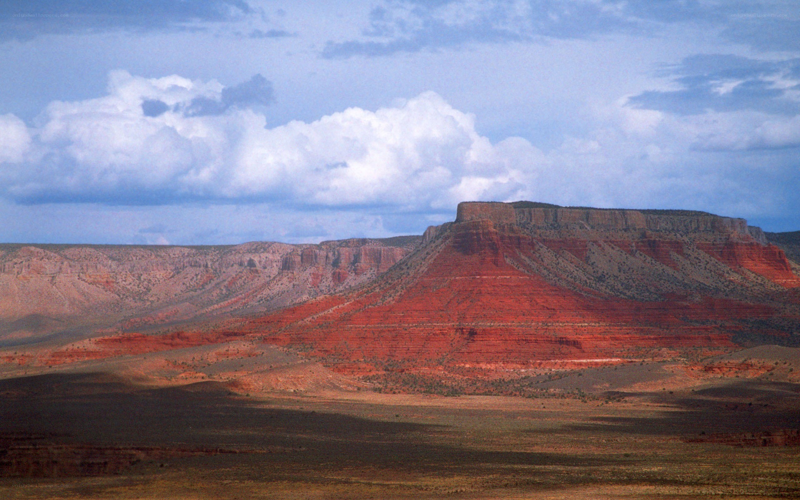 Red rock mesa under cloudy sky