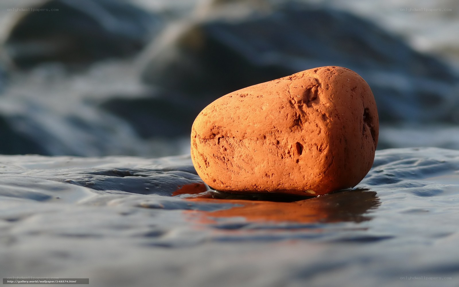 Red rock on wet sand