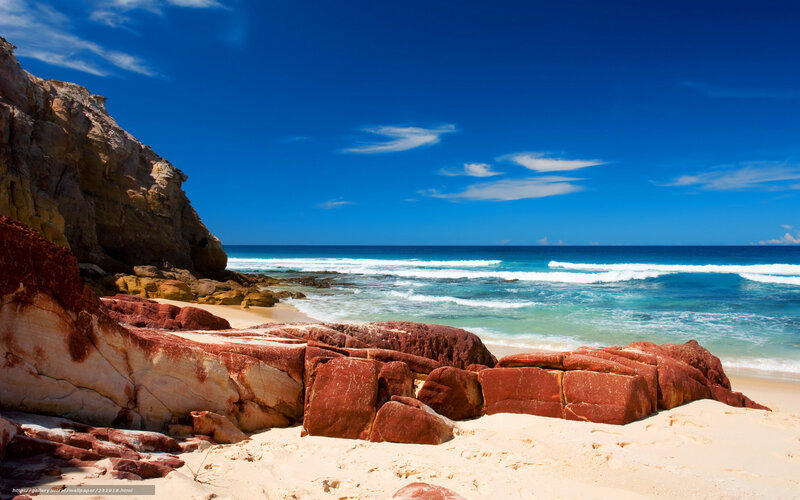 Red rocks on sandy beach