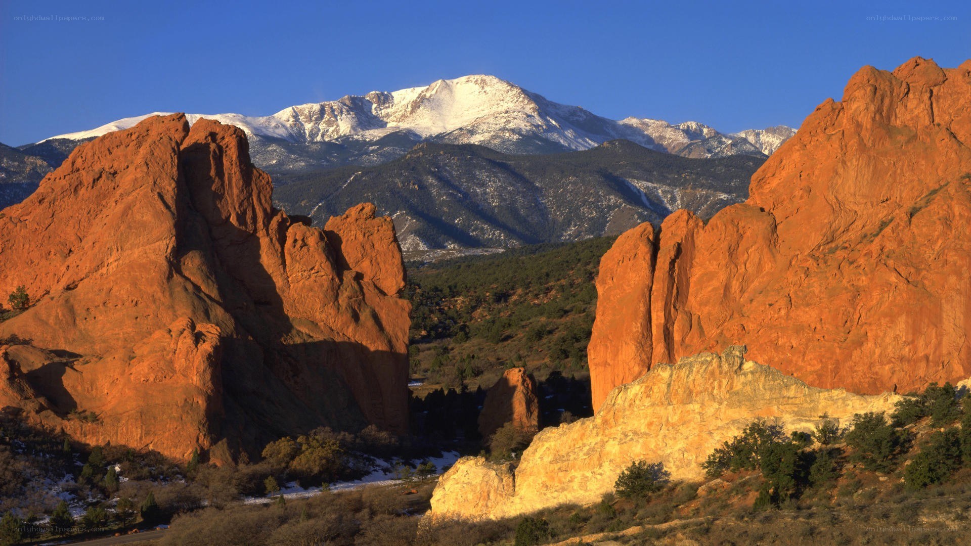 Red rocks with snow-capped mountains