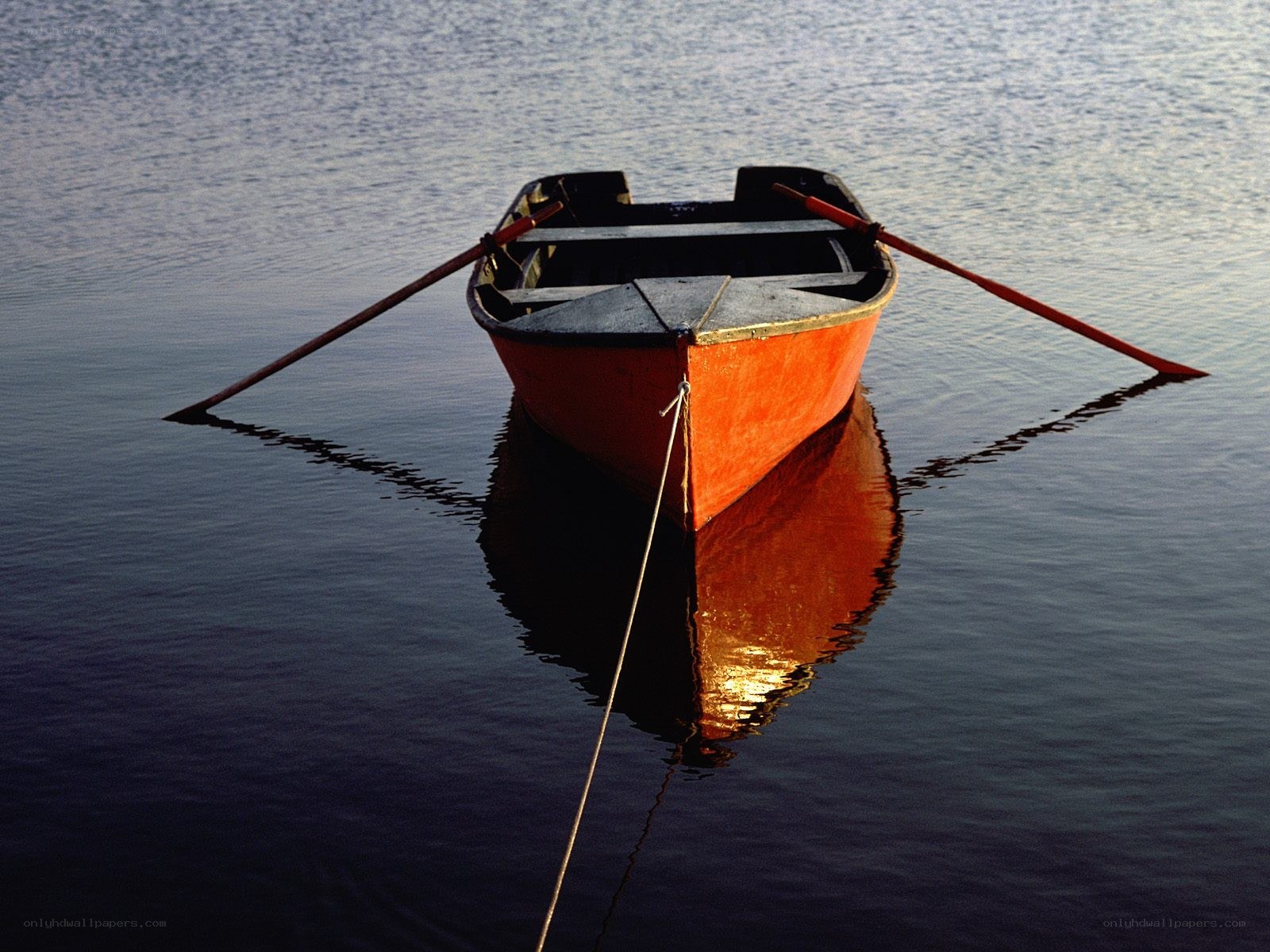 Red rowboat on calm water