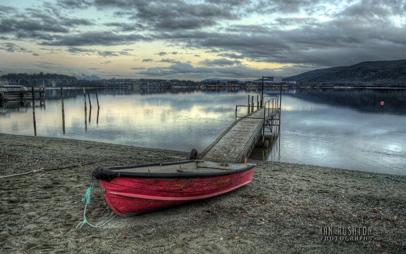 Red Rowboat on Shore — Serene, Sunset