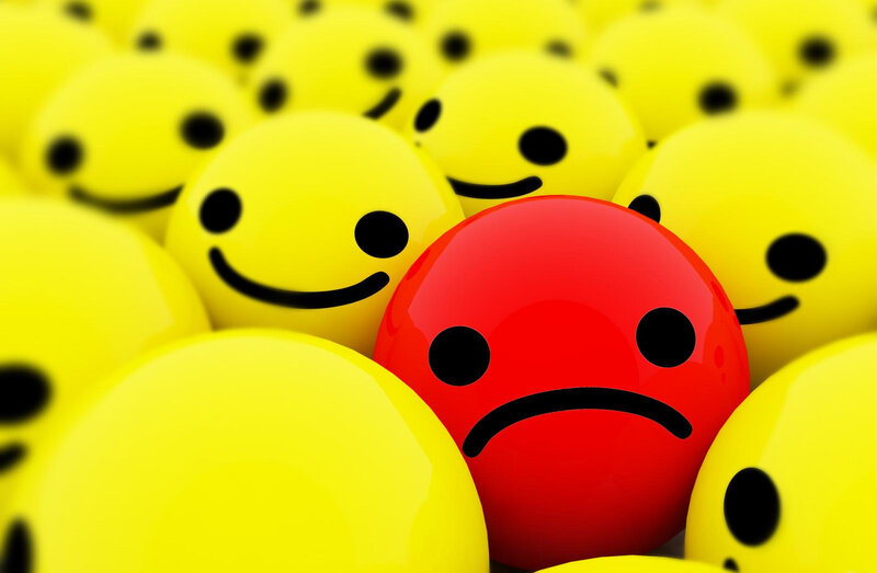 Red sad face among yellow smileys
