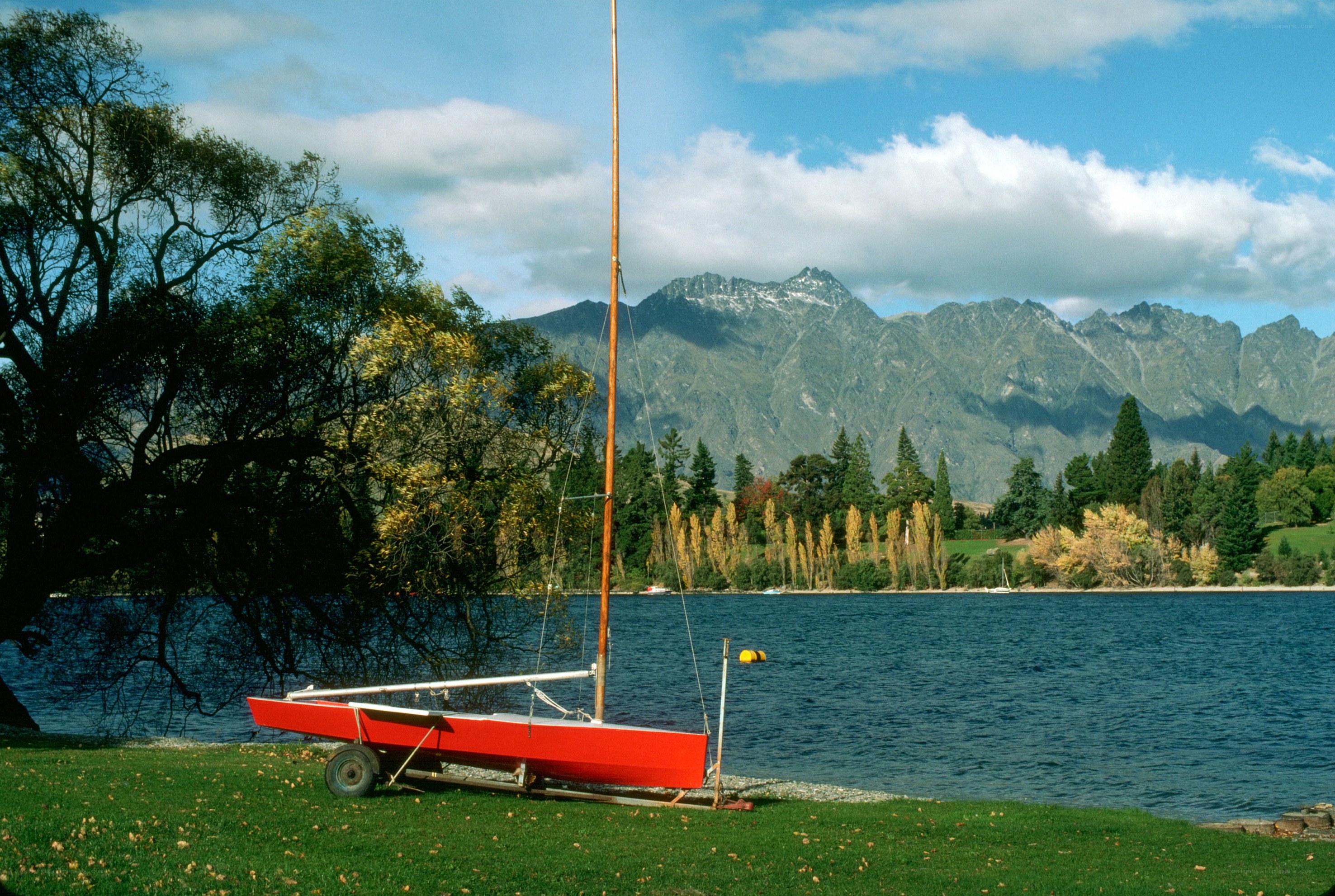 Red sailboat on a lakeside