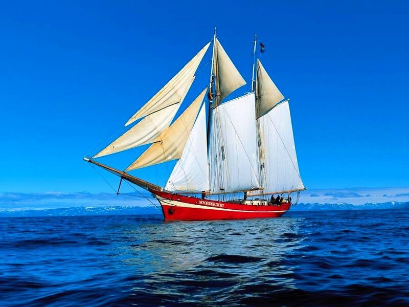 Red sailboat on blue sea