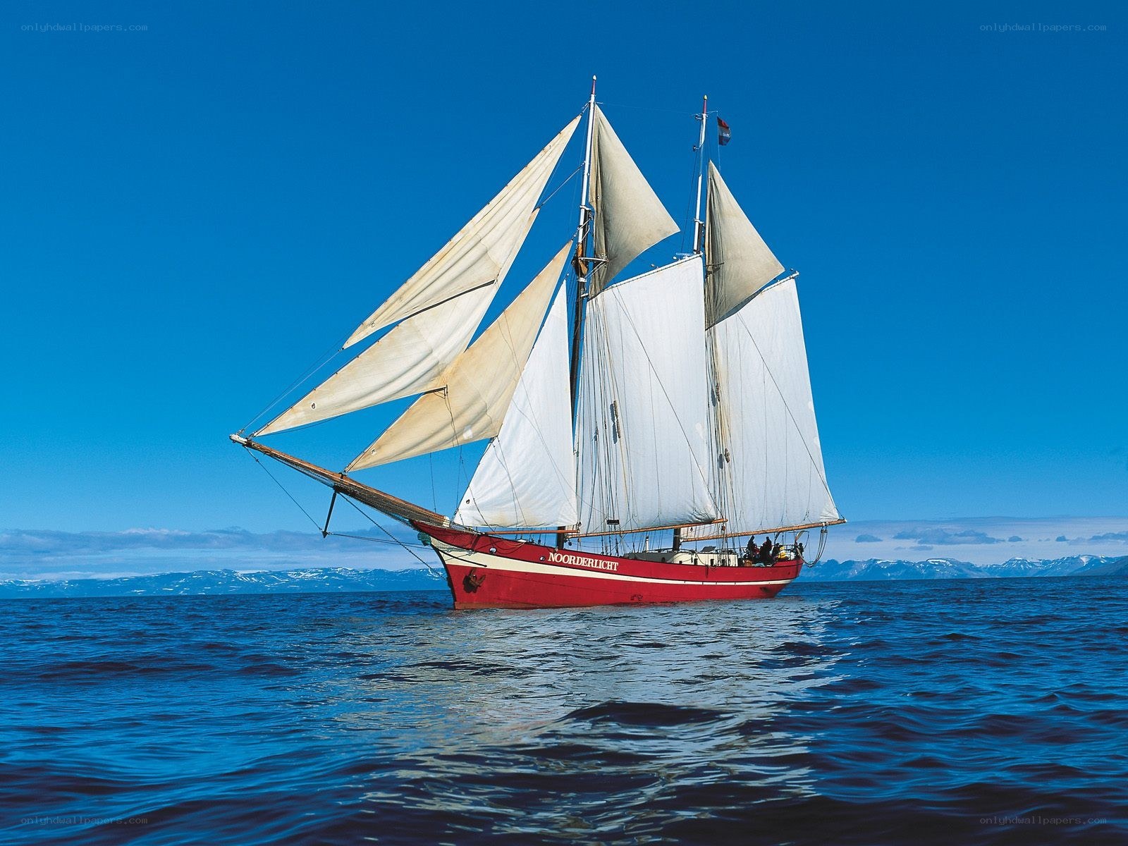 Red sailboat on blue sea