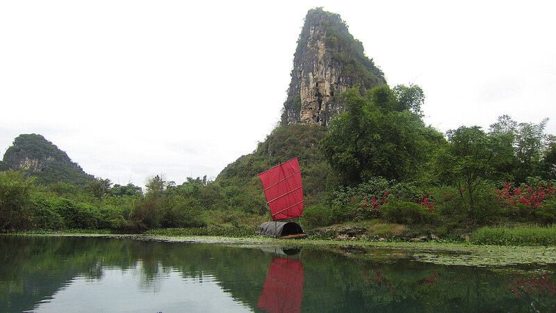 Red-sailed Boat on River