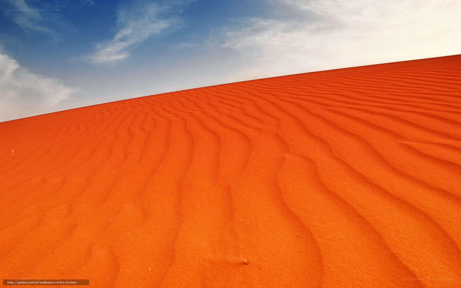 Red sand dunes under blue sky