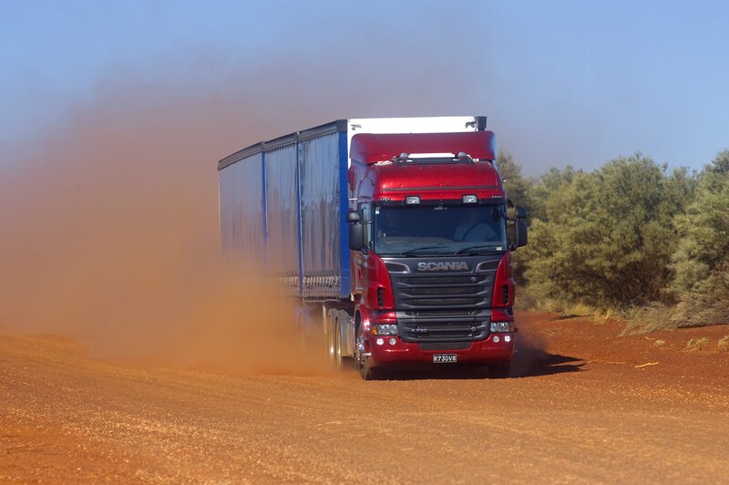 Red Scania truck on dirt road