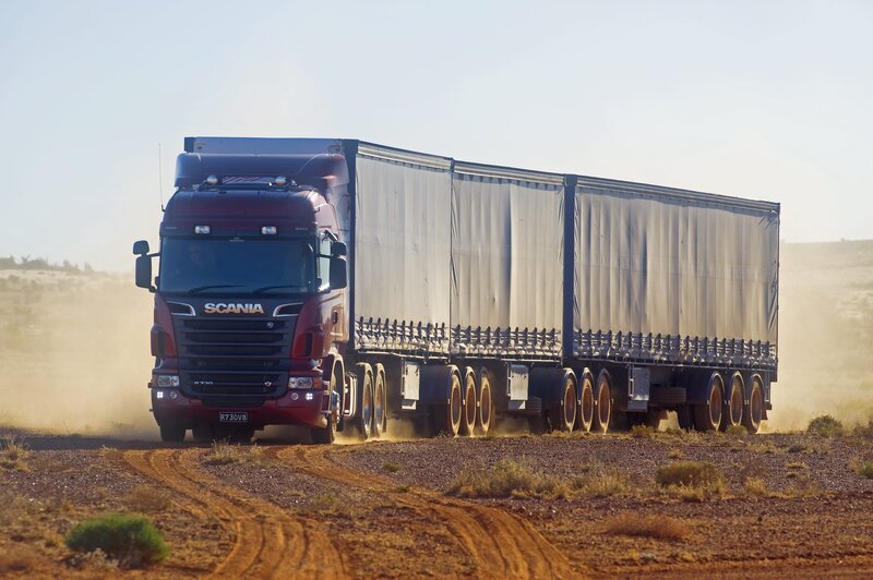 Red Scania truck on dirt road
