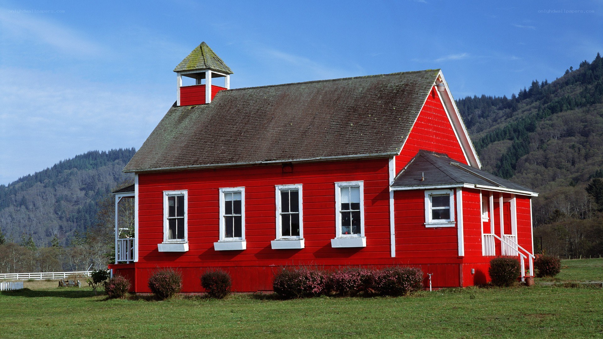 Red schoolhouse in rural landscape