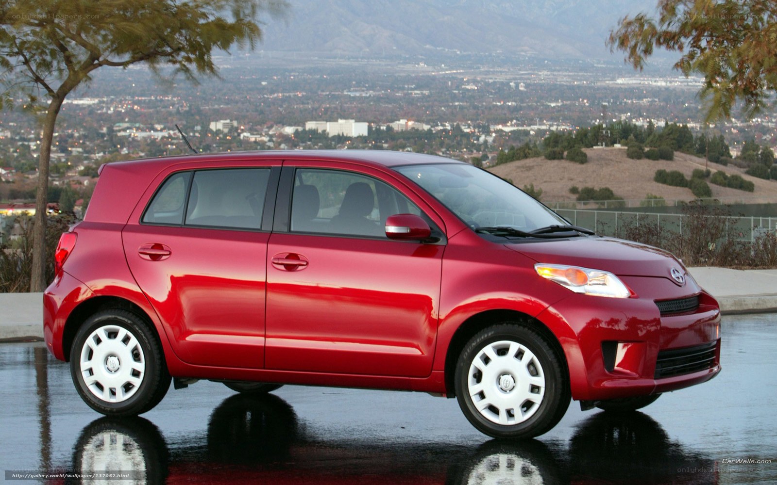 Red Scion xD parked on wet pavement