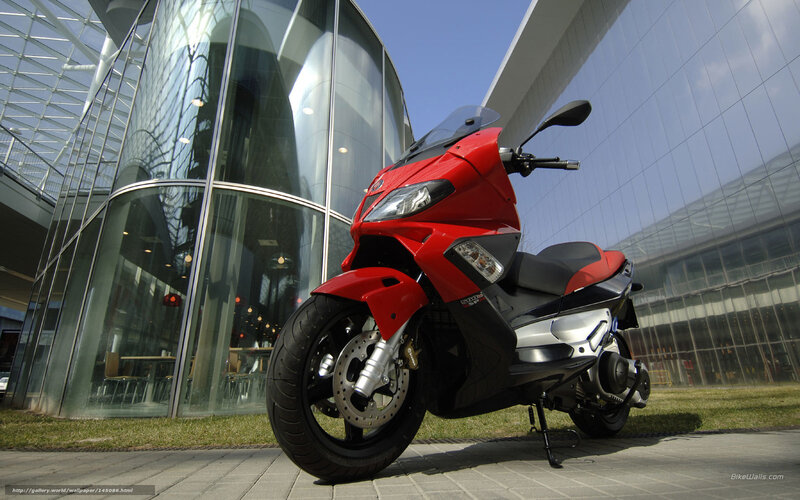 Red scooter in front of glass building
