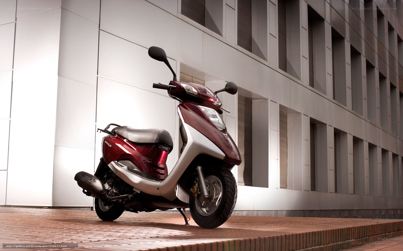 Red scooter on brick pavement