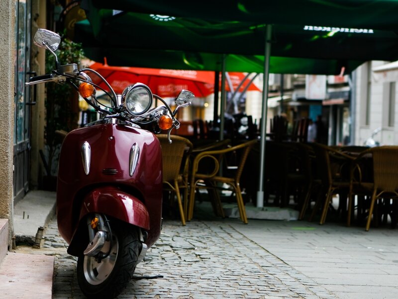 Red scooter on cobblestone street