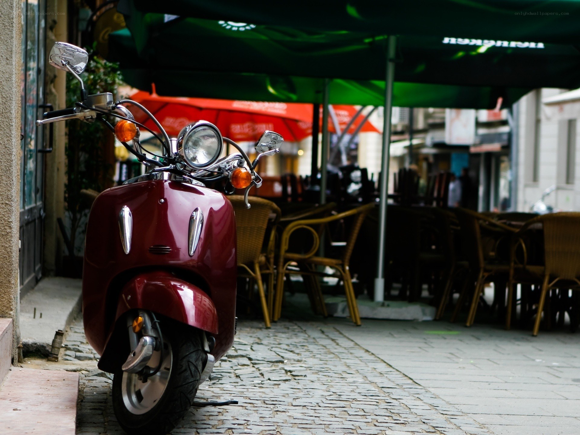 Red scooter on cobblestone street