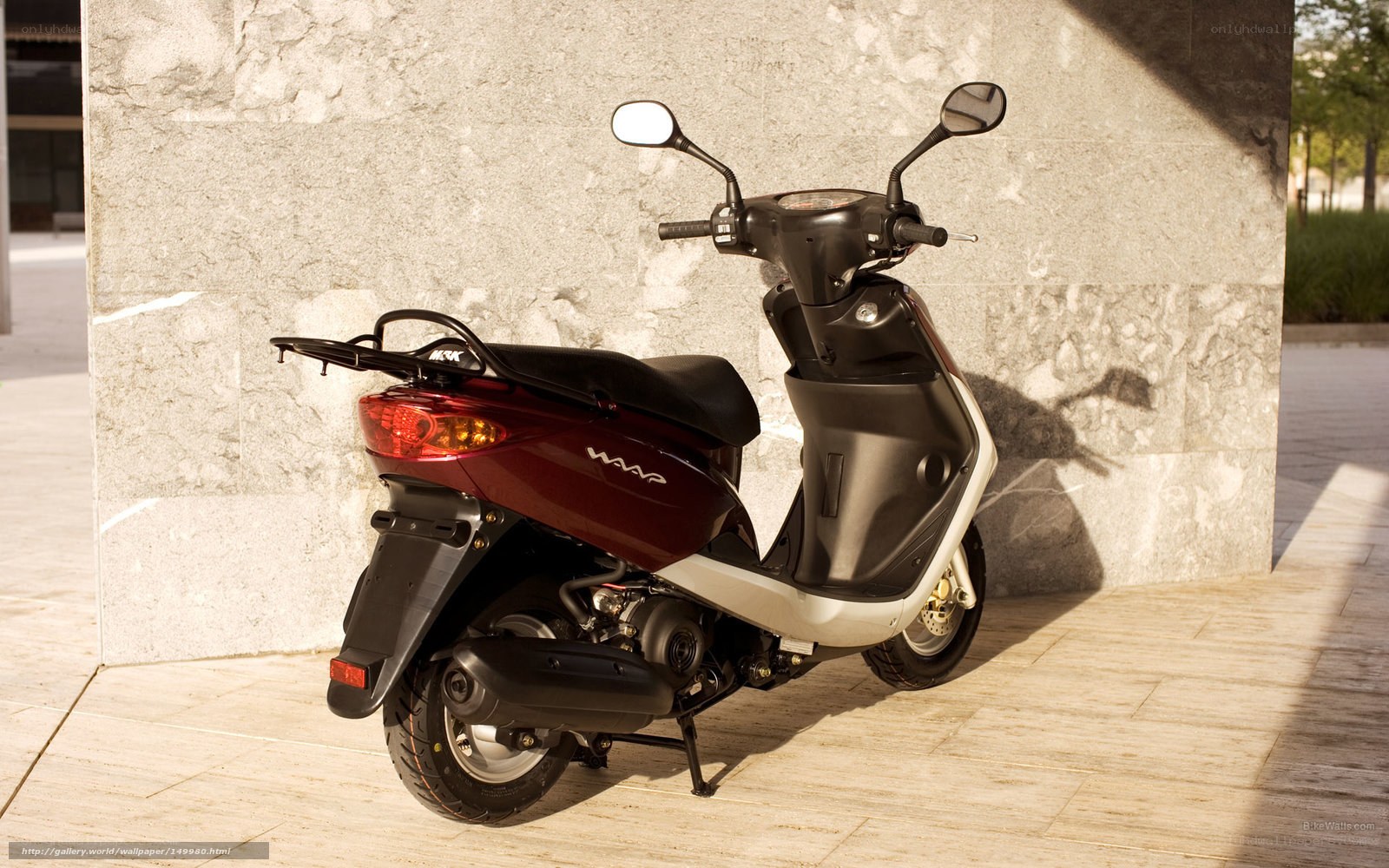 Red scooter parked against wall