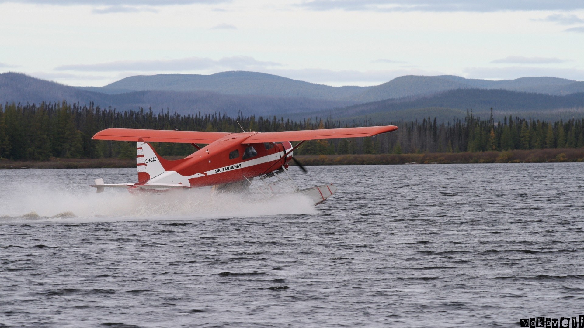 Red seaplane on lake
