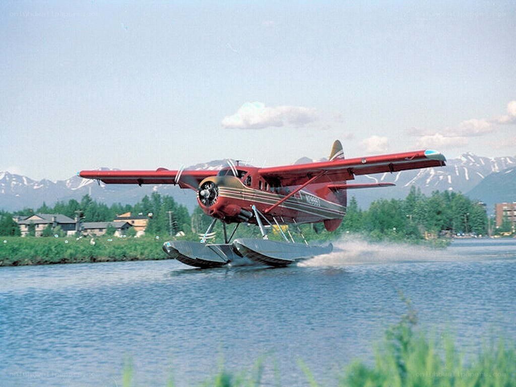 Red seaplane taking off from water