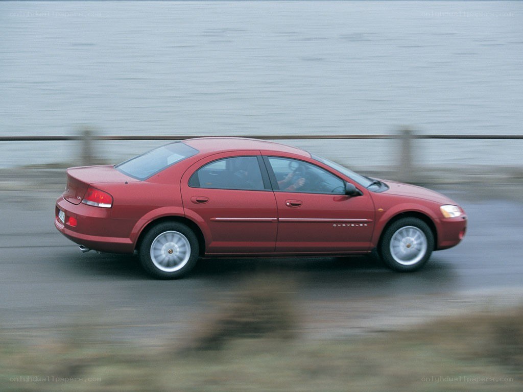 red sedan driving by water