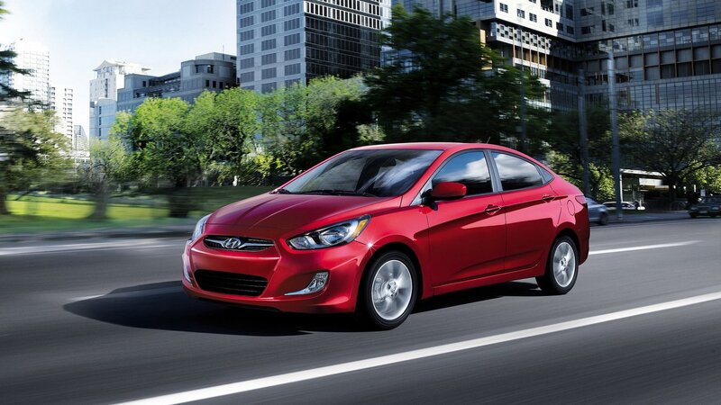 Red sedan driving in city