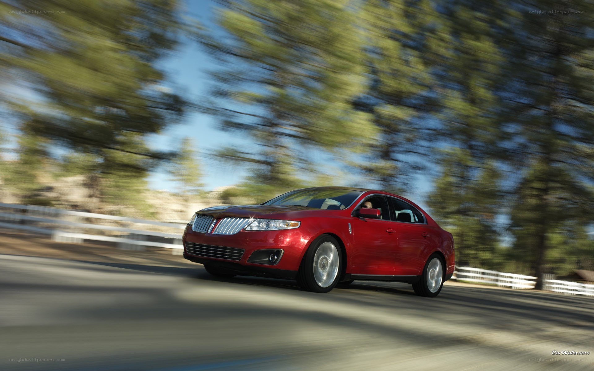 Red sedan driving on a road