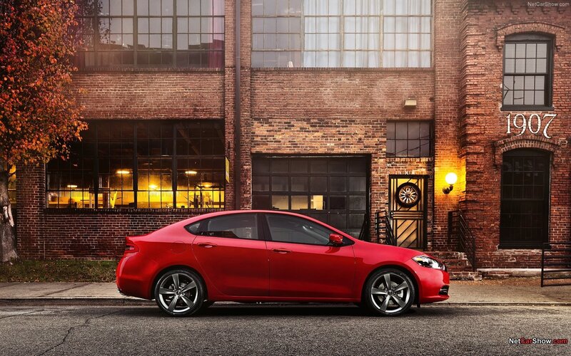 Red sedan in front of brick building