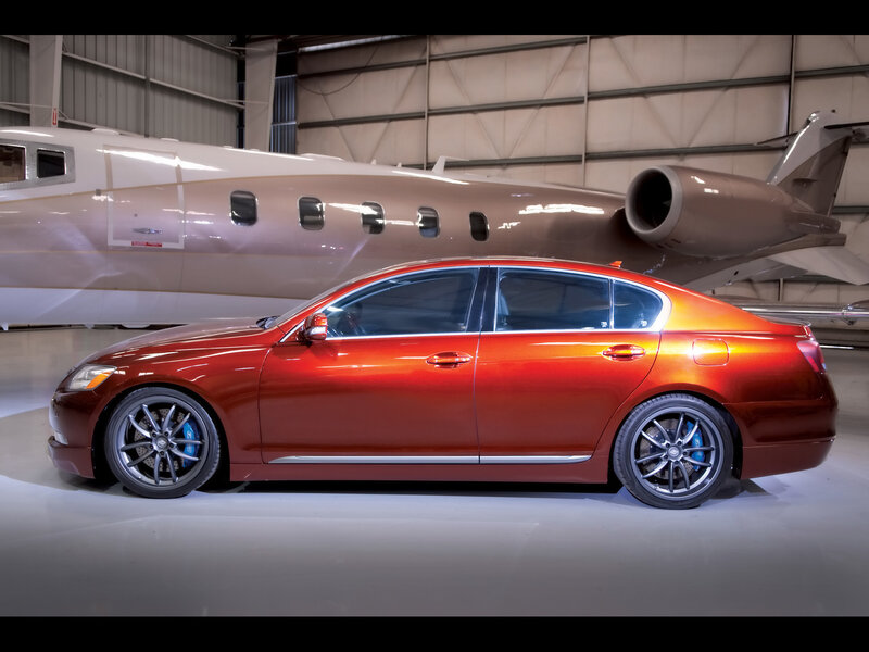 Red sedan in hangar with private jet