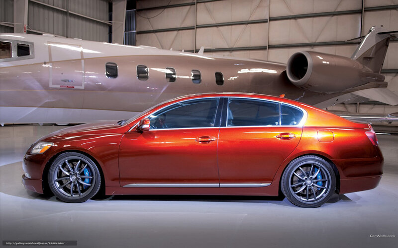 Red sedan in hangar with private jet