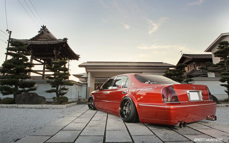 Red sedan in Japanese garden