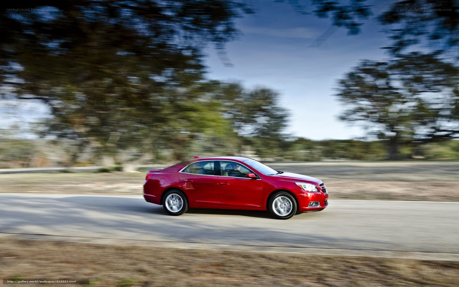 Red sedan in motion on road