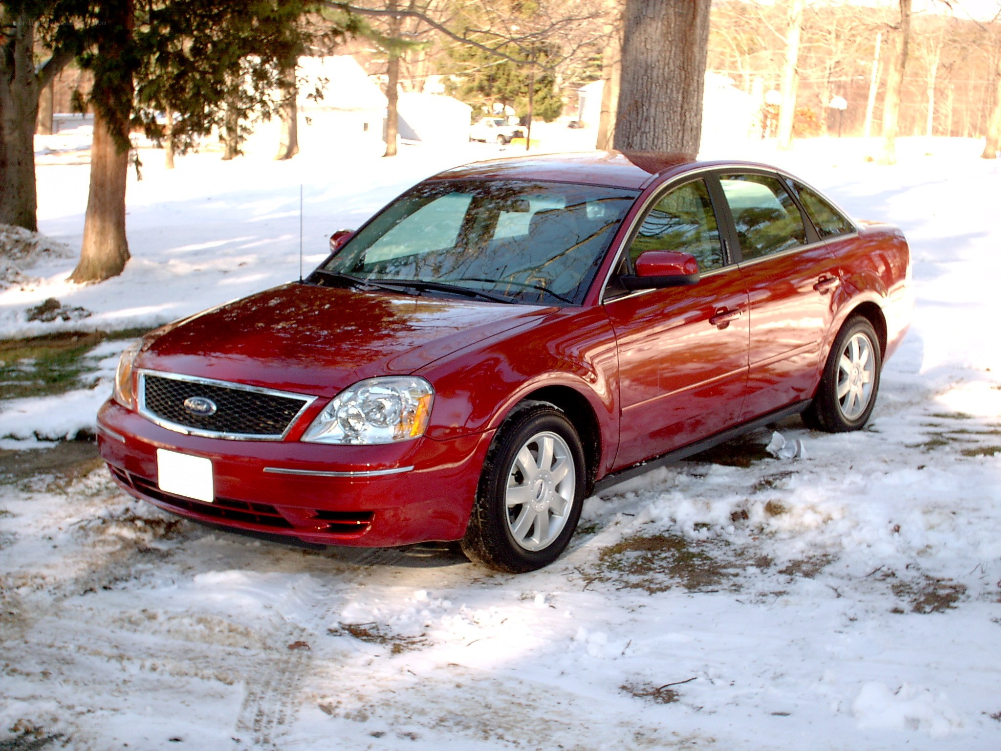 Red sedan in snowy yard