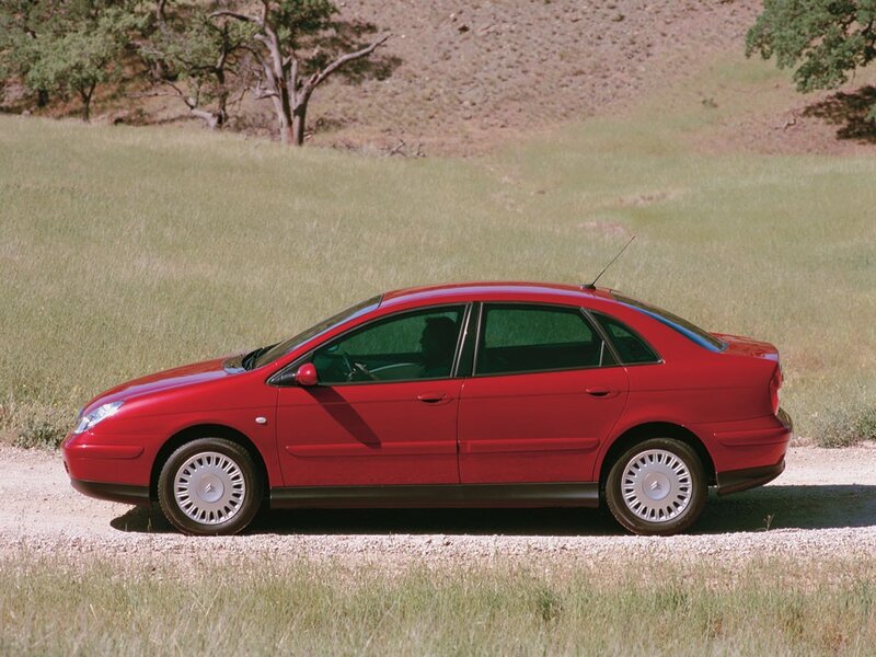 Red sedan on a gravel road