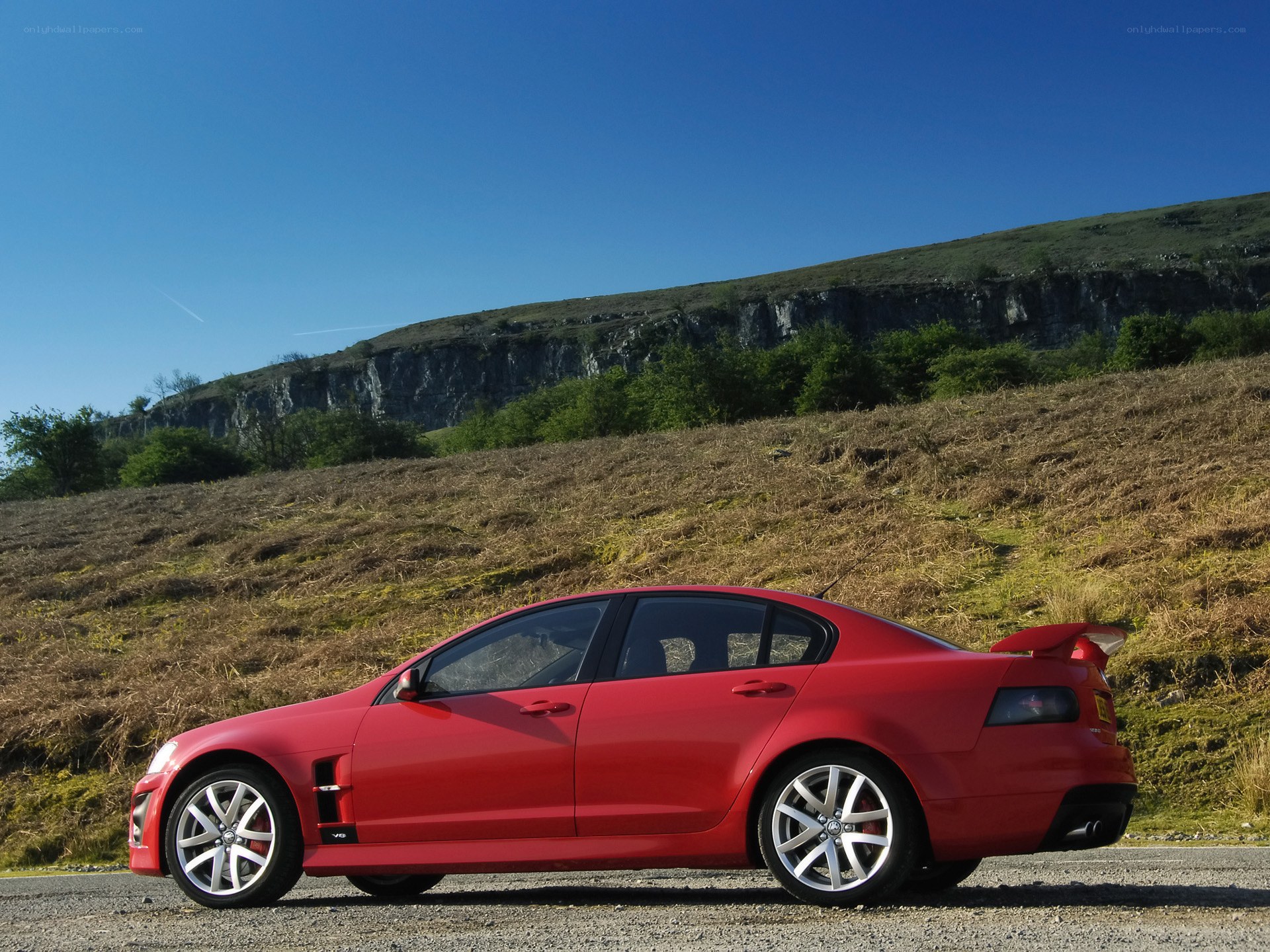 Red sedan on a hillside