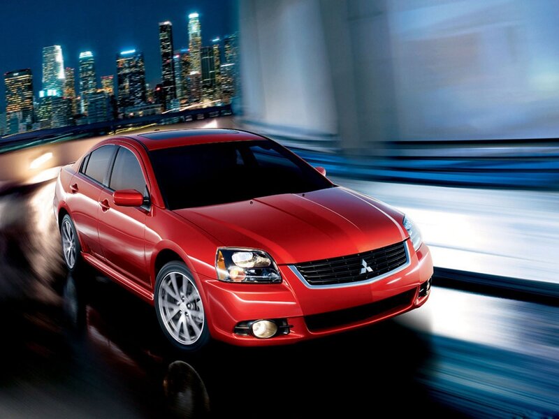 Red sedan on city bridge at night