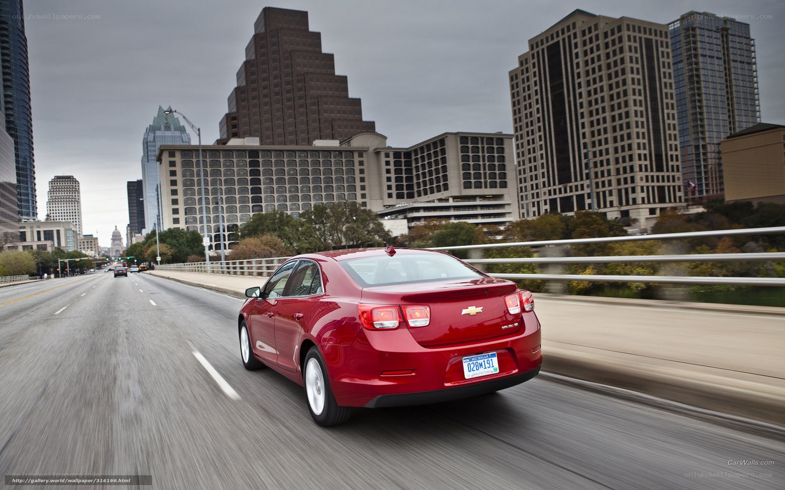Red sedan on city bridge