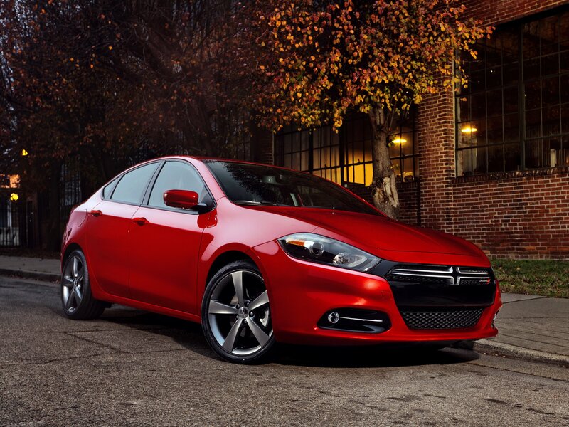 Red sedan on city street