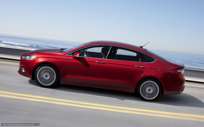 Red sedan on coastal road