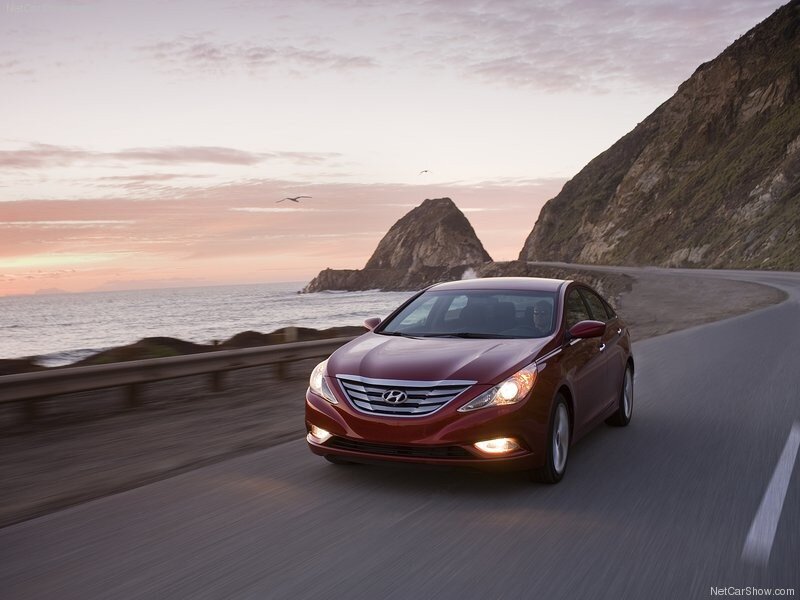 Red sedan on coastal road
