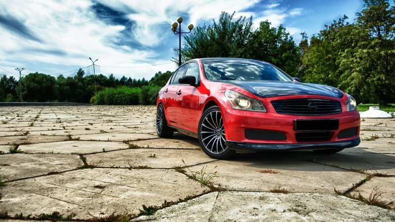Red sedan on concrete lot