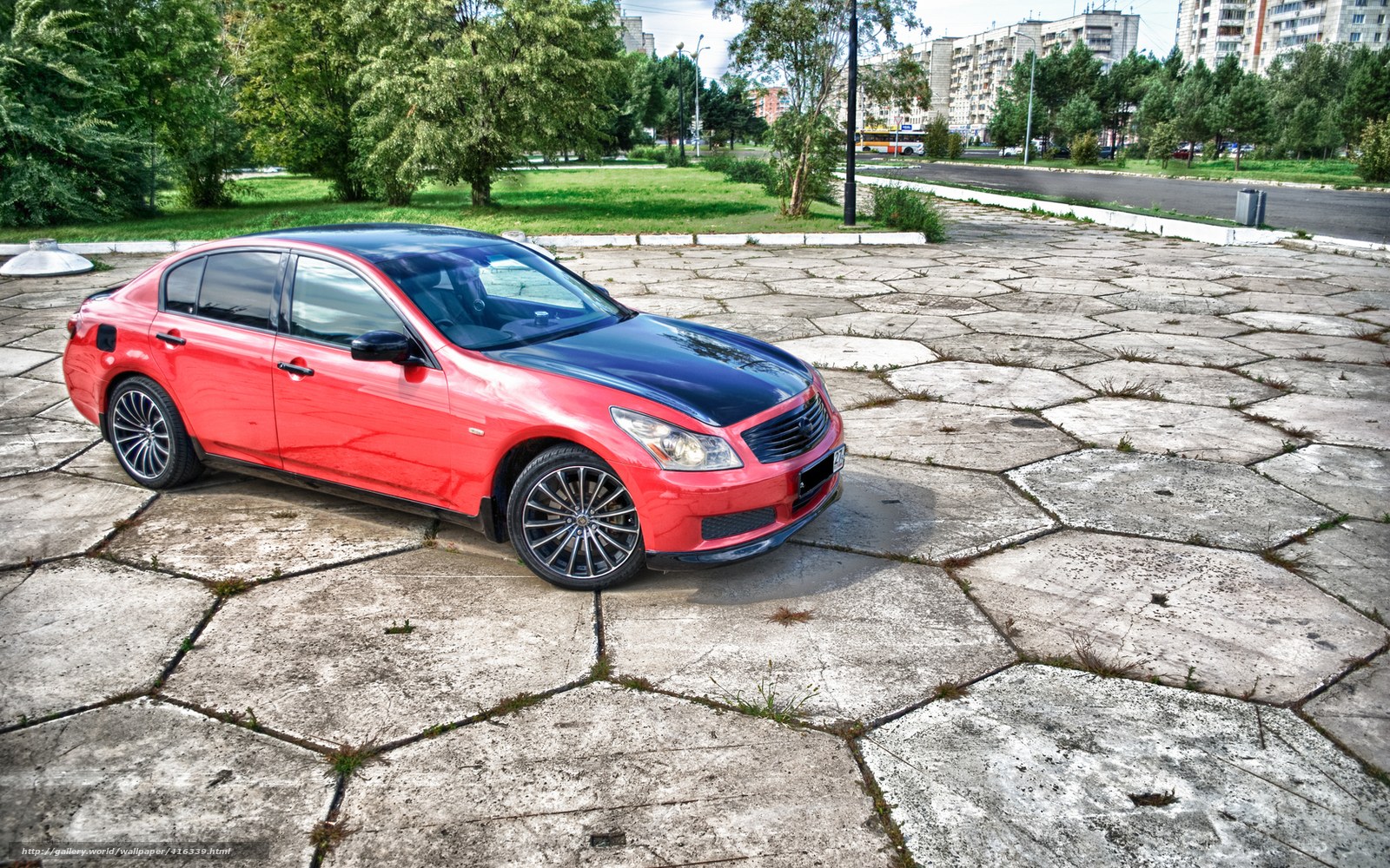 Red sedan on paved lot